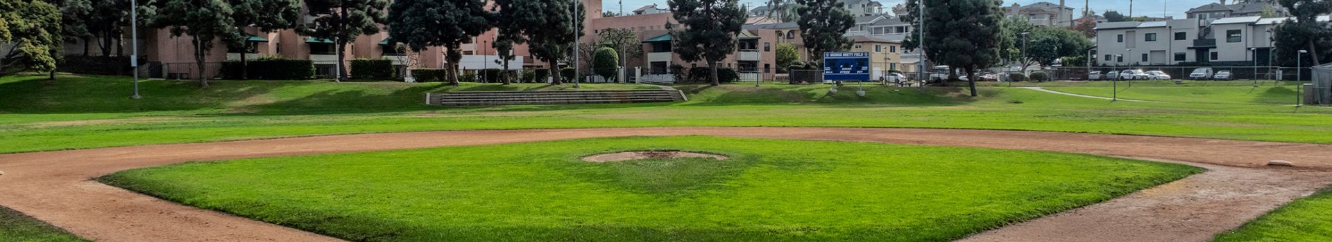 Brett Field with green grass and baseball diamond building in background