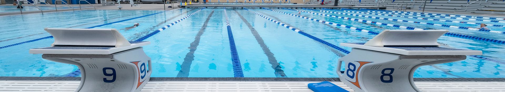 ES Wiseburn Aquatics Center pool with blue water and diving blocks and flags