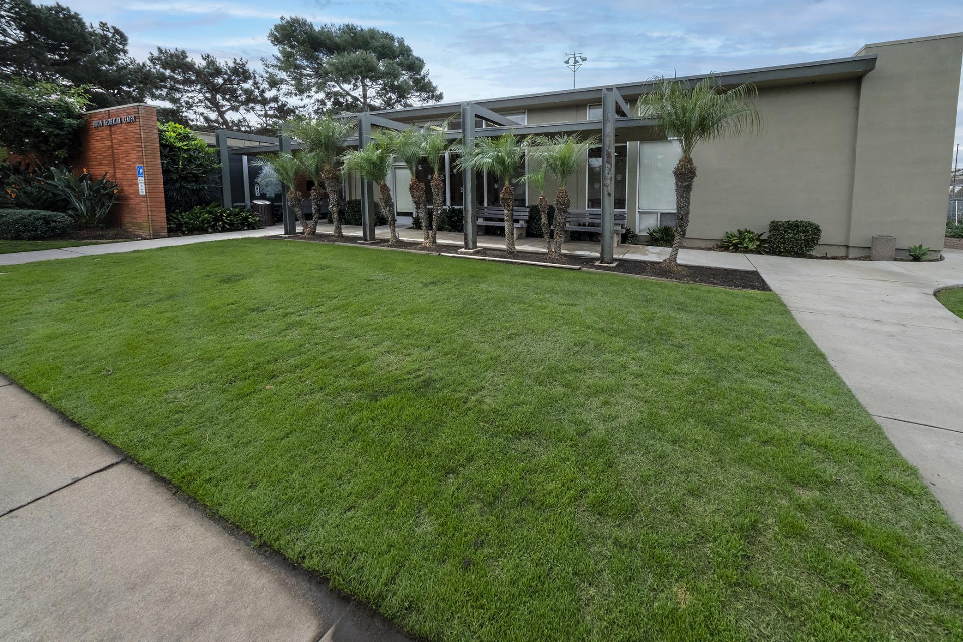 Joslyn Center with green grass out front and palm trees